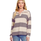 A woman wearing the FASHION GO Brushed Hacci Collared Top—a cozy, lightweight long-sleeve shirt featuring wide beige and gray horizontal stripes—paired with blue jeans, stands against a white background.