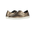 Inez Flat Leather Sneaker by Eric Michael—metallic bronze slip-on casual shoes featuring a woven cutout design with star-shaped details and white rubber soles, displayed on a white background.