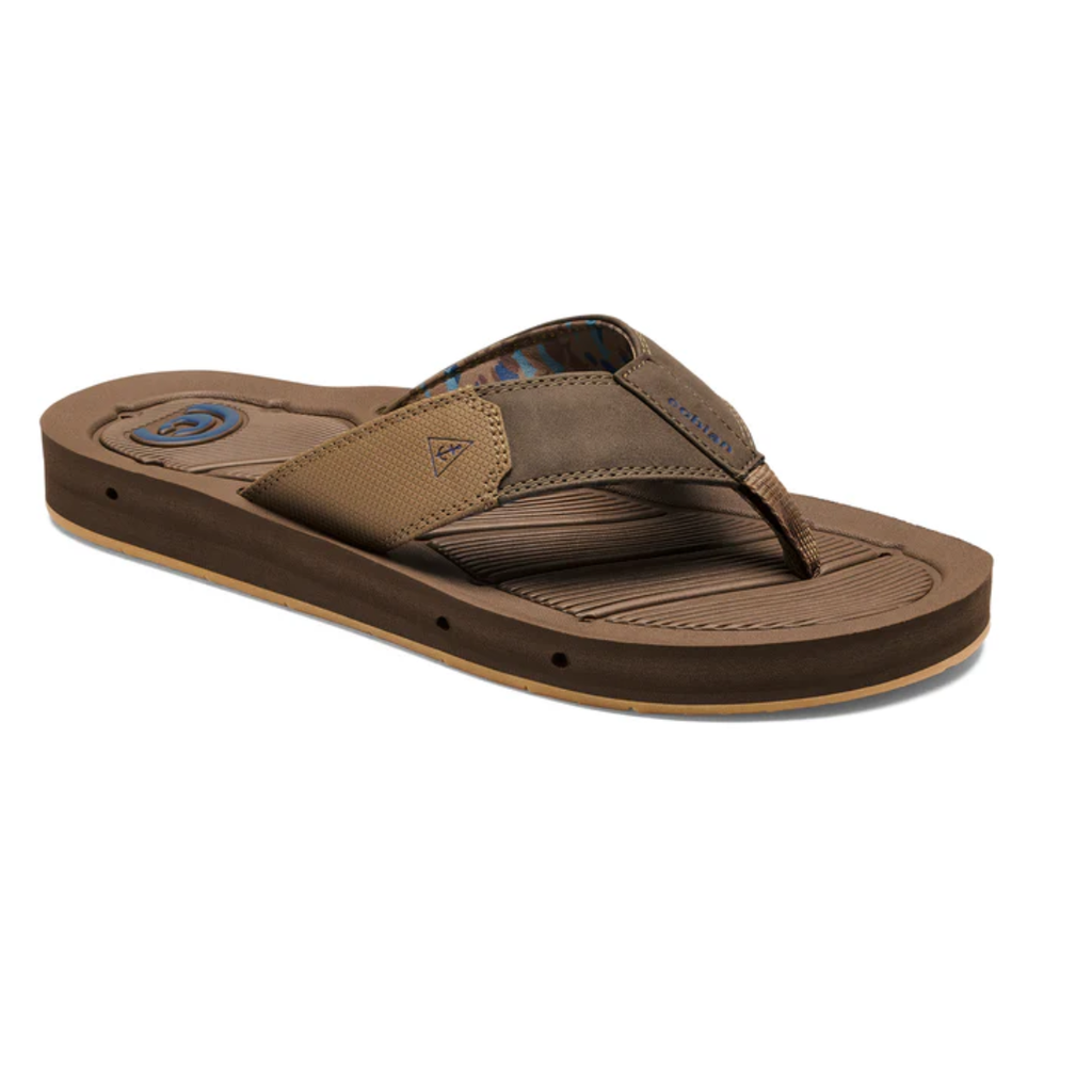 The COBIAN Men's Draino 2 Flip Flop in brown features wide fabric straps, a textured non-slip footbed, and a slightly elevated sole, shown against a white background.