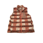The Umgee Fleece Zip Up Vest features a brown, cream, and rust plaid pattern with a checkered chest pocket. This cozy sleeveless vest is perfect for fall layering. Shown laid flat on a white background.