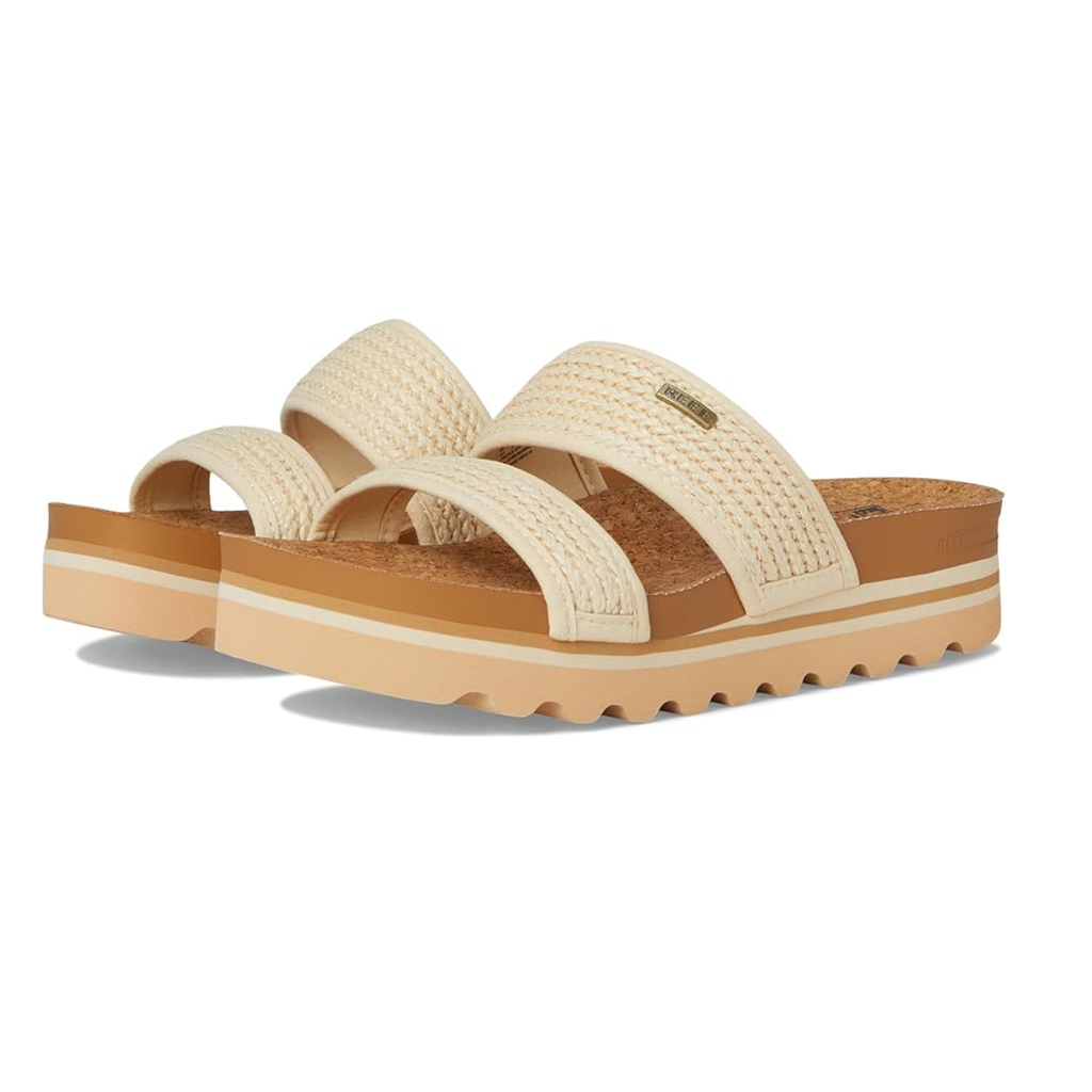 The REEF Cushion Vista Hi in Vintage Raffia features cream-colored vegan leather, a woven texture, wide double straps, a thick brown sole with arch support, and a ridged bottom.