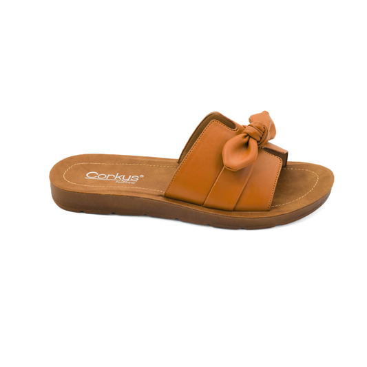 The Too Cute in Cognac sandal by CORKY'S FOOTWEAR INC features a brown knotted strap, flat cushioned sole, and the brand name on the footbed for stylish comfort.