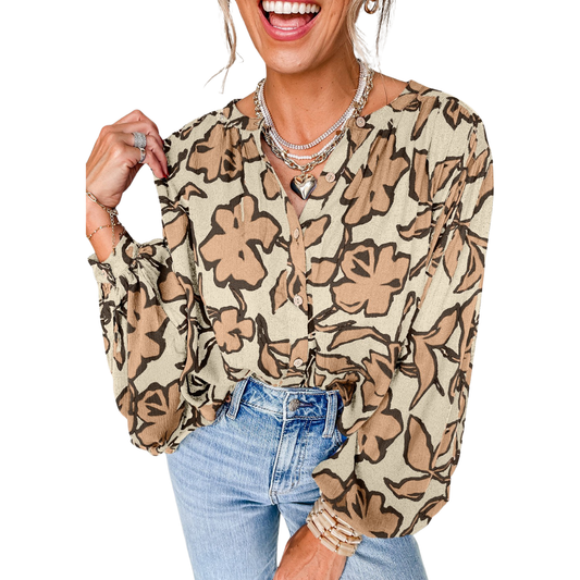 A woman smiles against a white background, wearing the FASHION GO Floral Batwing Sleeve Button Blouse in Parchment, paired with light blue high-waisted jeans, layered necklaces, and bracelets.