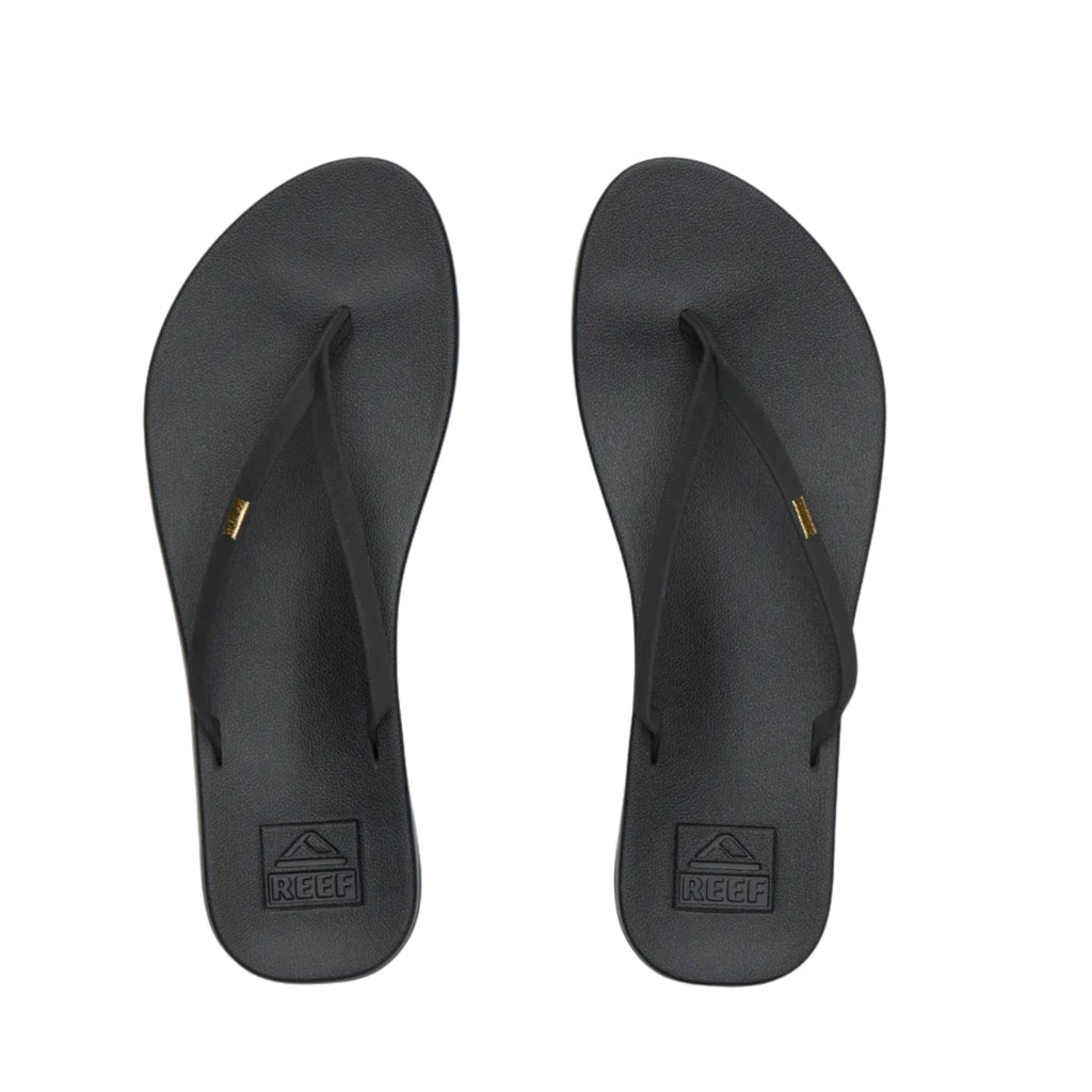 A pair of REEF Cushion Slim Flip Flops in Black, featuring thin straps and the REEF logo on a cushioned footbed, viewed from above on a white background—the perfect summer sandals for everyday wear.