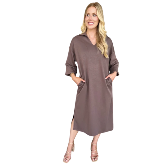 A woman in the Carole Christian Scuba Fabric Dress, a loose-fitting, midi-length style with three-quarter sleeves and side pockets, made in the USA, paired with strappy heeled sandals.