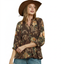 Woman wearing a wide-brimmed hat and a brown long-sleeved Umgee Floral Ruffle Neck Split V-Neck Blouse.