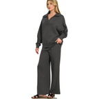 A person wearing a FASHION GO Scuba Collared Pullover and Pants Set in charcoal gray, featuring a scuba collared pullover and matching center seam wide-leg trousers.