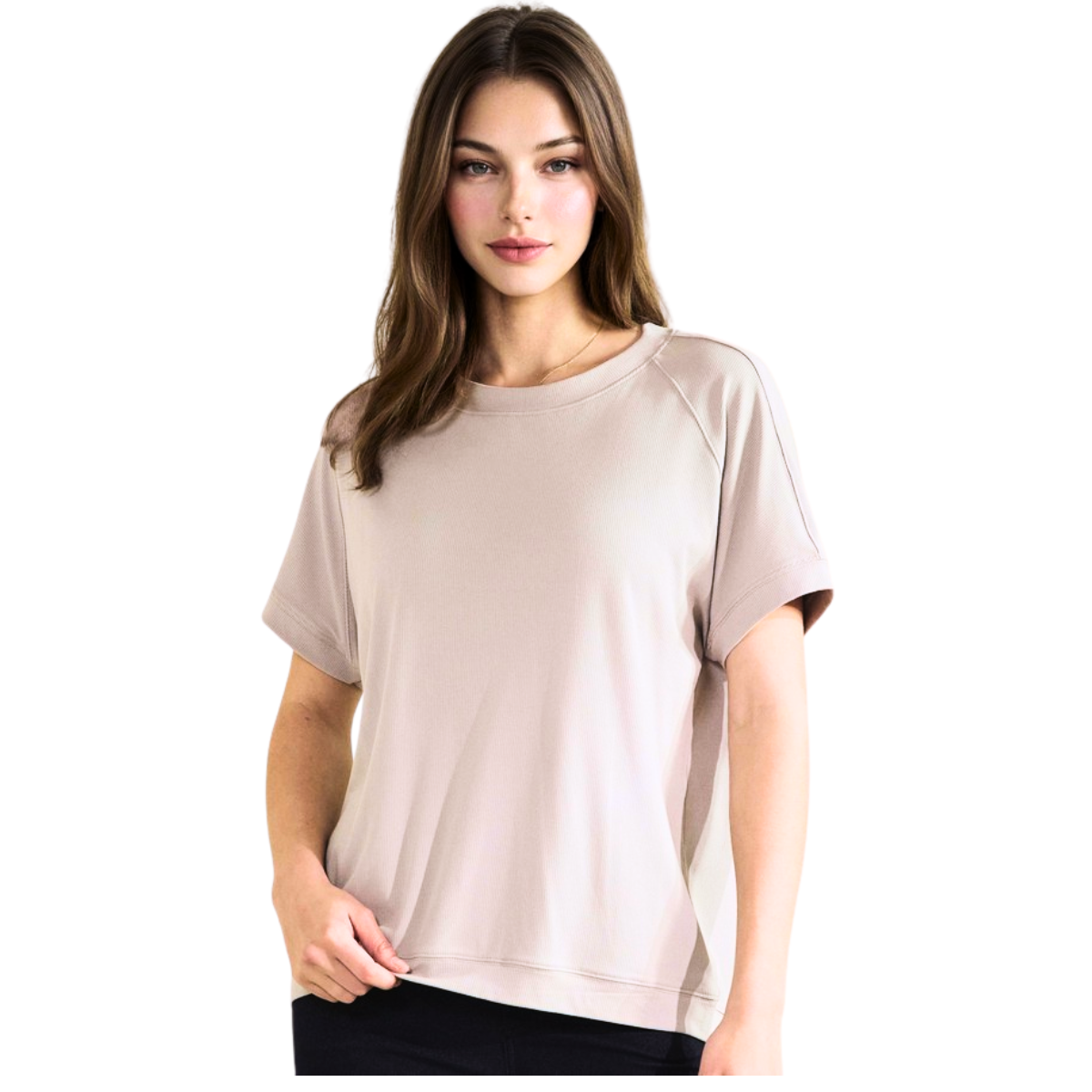 A woman with long brown hair wears the FASHION GO Everyday Soft Ribbed Loose Fit Short Sleeve Top in beige and black pants, standing against a white background—an essential for effortless style.