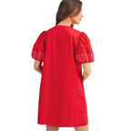 A woman stands with her back to the camera wearing the FASHION GO Short Puff Sleeves Embroidered Shift dress, which features short, gathered sleeves with intricate embroidered detailing near the cuffs.