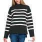 A woman wears the FASHION GO Striped Mock Neck Sweater with black and ivory stripes and blue jeans, highlighting a cozy knit style ideal for casual outings.