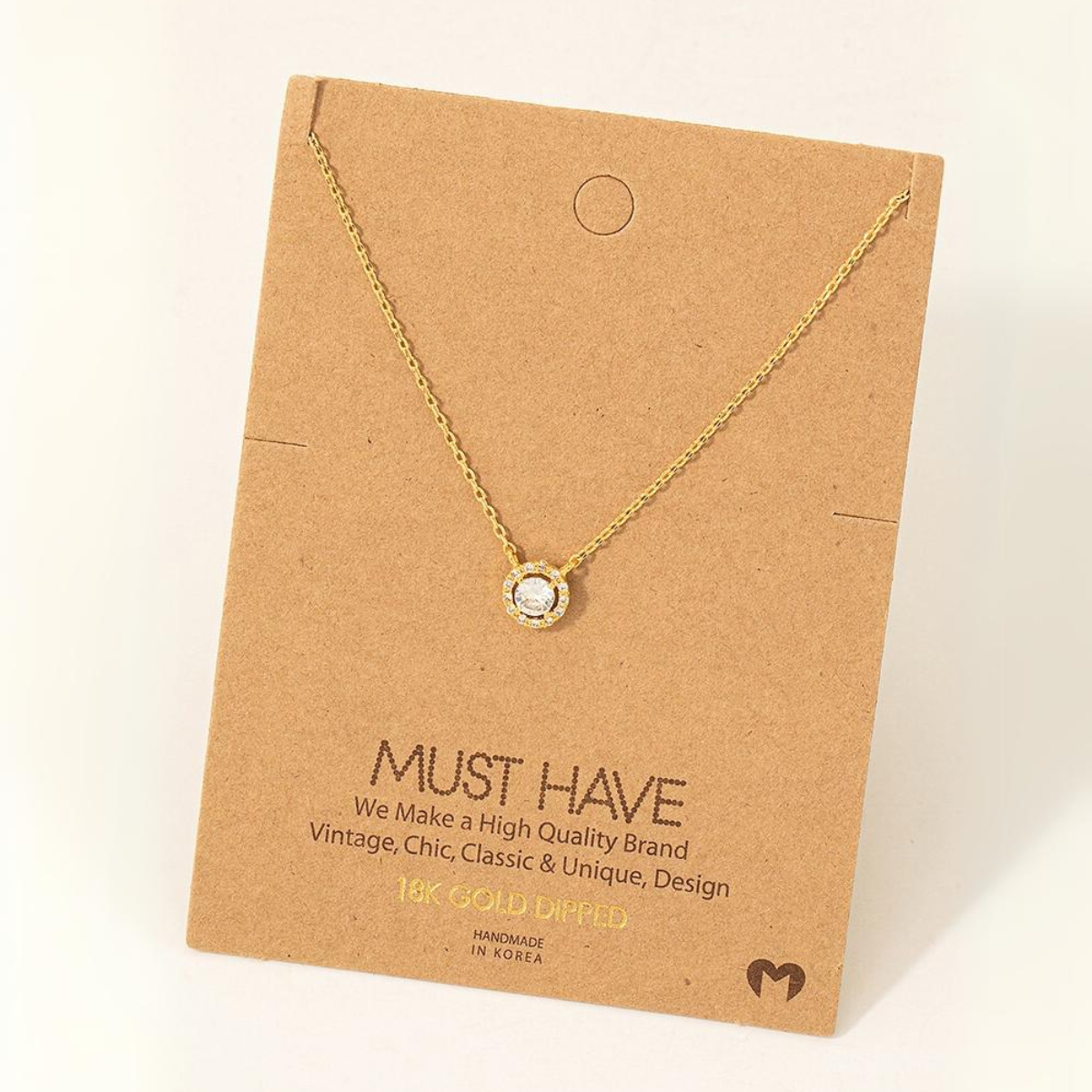 A Gold Dipped Cubic Zirconia Halo Pendant Necklace, displayed on a brown card that reads "MUST HAVE." The card mentions it is a high-quality, handmade product from Korea by FASHION GO. Main image