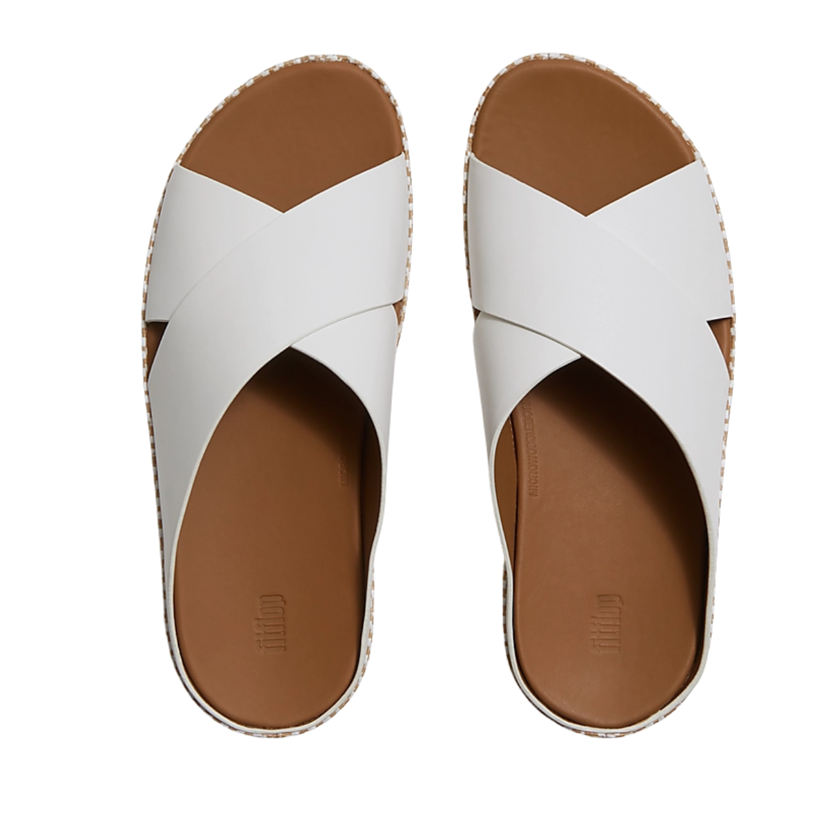 The fit flop Lulu Lux Graphic Weave Leather Cross Cross Slides feature white wide crisscross leather straps and brown footbeds, shown from above for a stylish summer look.