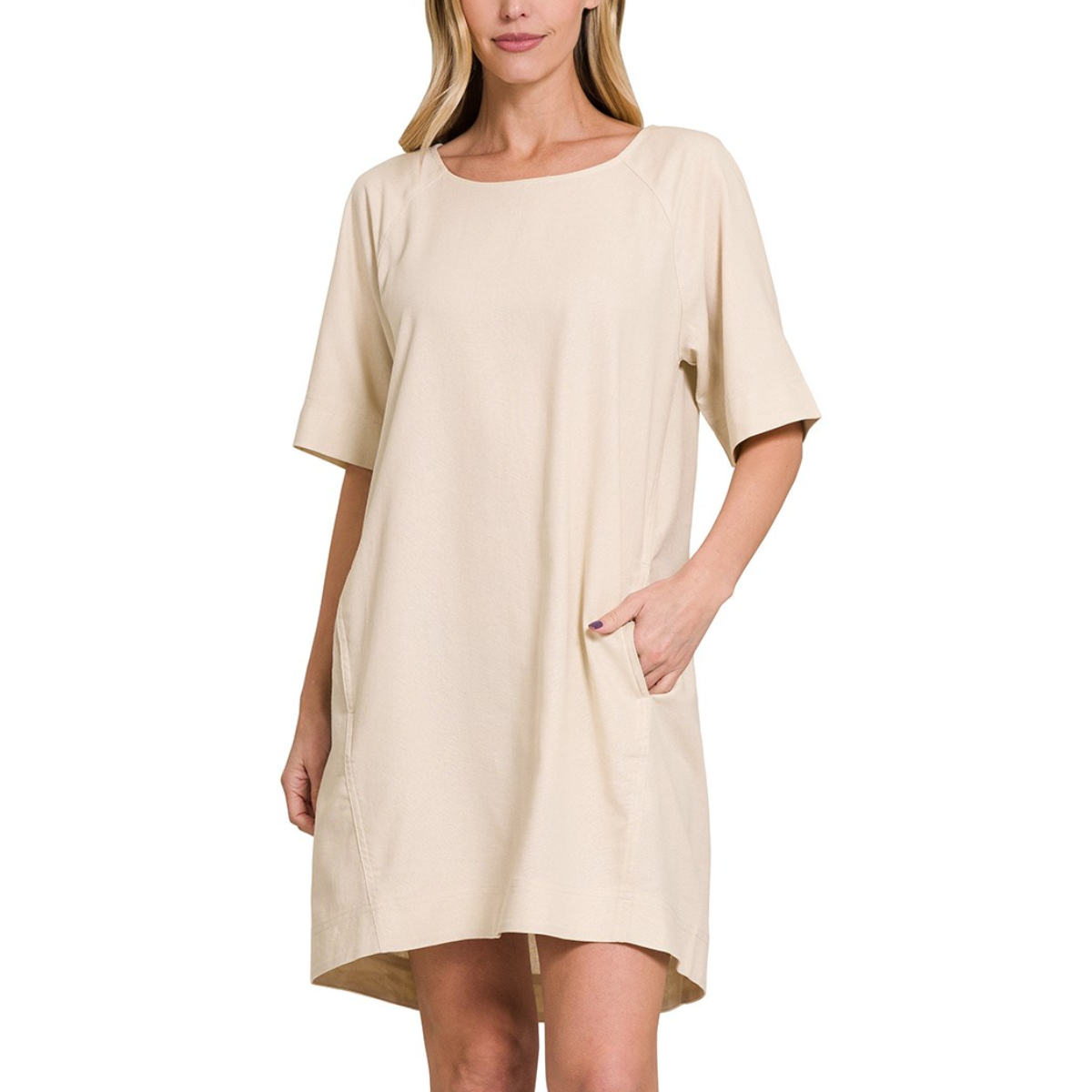 A person wearing a loose-fitting, beige FASHION GO Linen Short Sleeve Dress with Side Pockets stands against a plain white background, with one hand casually resting in a pocket.