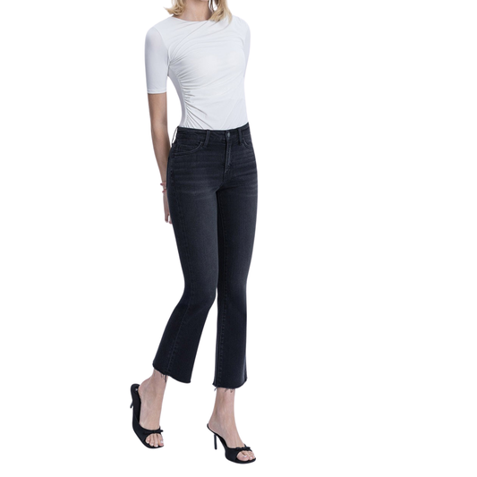 A person wearing a fitted white short-sleeve top, FASHION GO High Rise Raw Hem Ankle Bootcut Jeans - Black, and black open-toe heels stands against a white background.