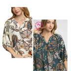 Two women model the Umgee Boho Paisley Puff Sleeve Blouse in two different colors—cream and teal—each showcasing a split neckline and three-quarter puff sleeves.
