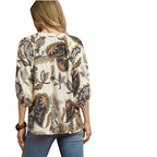 A woman stands with her back to the camera, wearing the Umgee Boho Paisley Puff Sleeve Blouse and blue jeans.