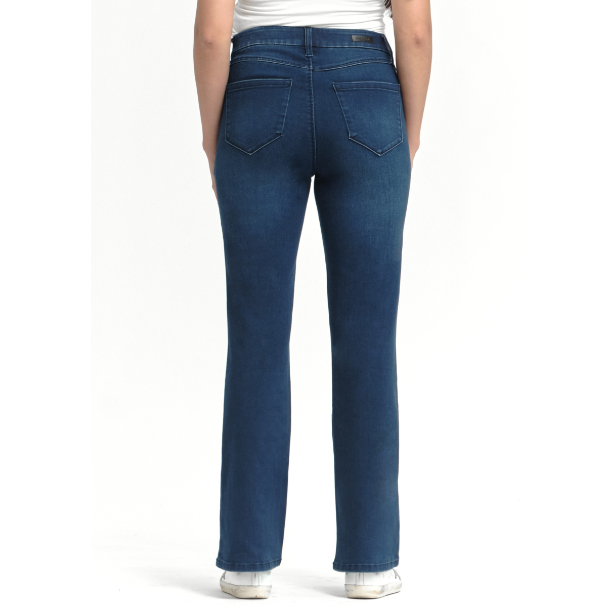 Model wears FASHION GO 30'' Better Butter Slim Boot Jean In Belle and white sneakers, photographed from the back against a plain white background.