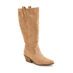 The City Slicker Faux Suede Tall Boot by CORKY’S FOOTWEAR features a tan sand faux suede upper, knee-high western silhouette, low stacked heel, pointed toe, and convenient pull tabs at the top. This cowgirl boot is shown against a white background.