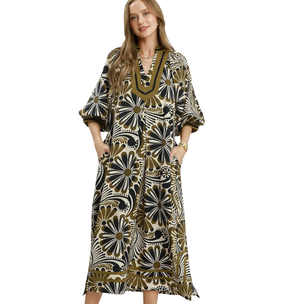 A woman models the Umgee Abstract Print Midi Dress featuring black, white, and olive green floral designs with pockets. The flowy midi silhouette brings effortless style against a white background.