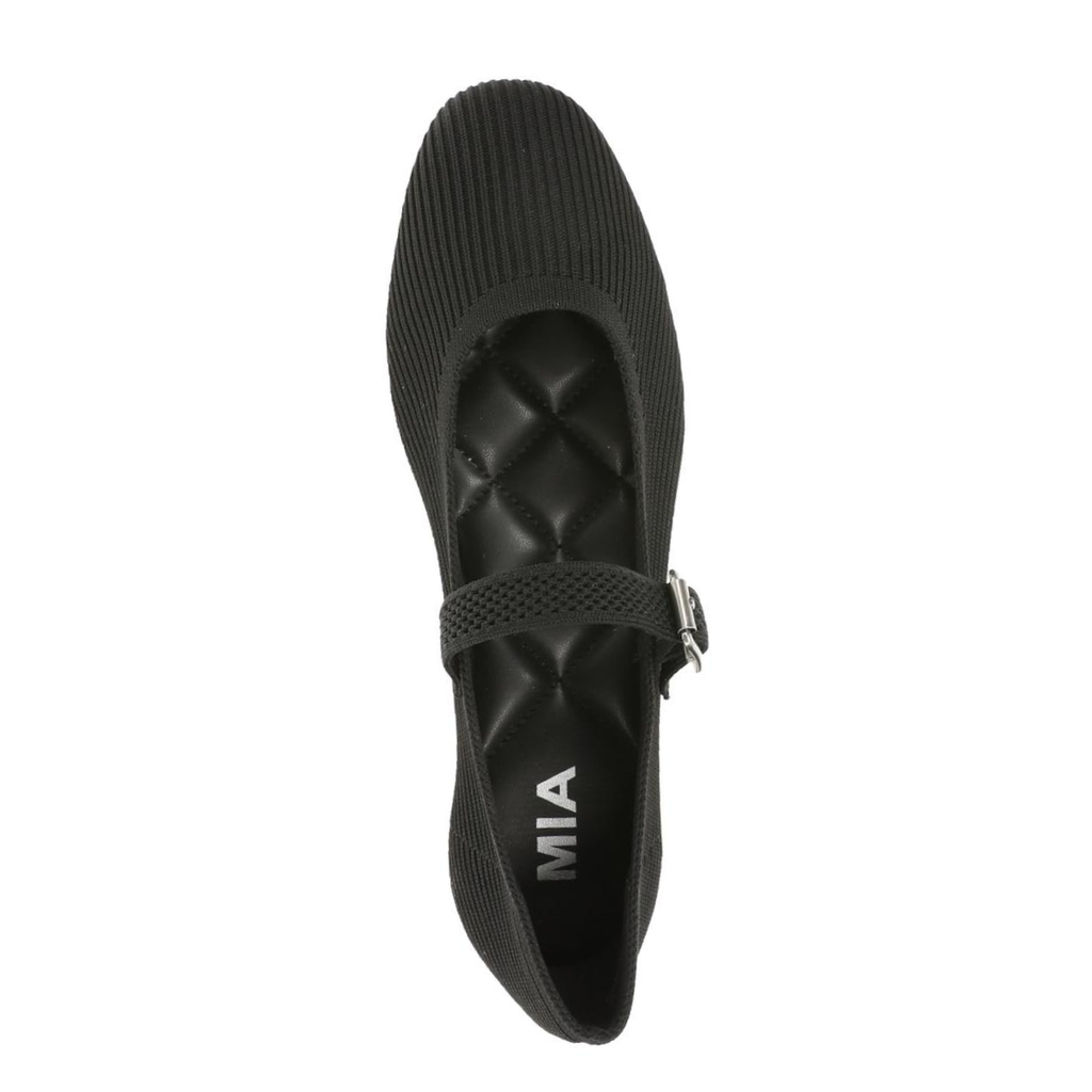 The Brita Knit MaryJane Ballet Flat by MIA features a black textured, ribbed surface with a buckle strap and quilted insole, seen from above. These stylish flats are designed with a cushioned footbed for enhanced all-day comfort.