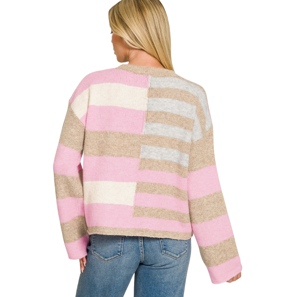 A woman in blue jeans is shown from the back wearing the FASHION GO Lightweight Wool Blend Color Block Sweater, featuring wide pink, beige, ivory, and gray stripes—a perfect addition to your fall wardrobe.