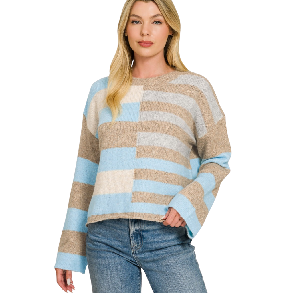 A woman models the FASHION GO Lightweight Wool Blend Color Block Sweater, featuring long sleeves and beige, blue, and cream stripes, styled with blue jeans—an ideal addition to your fall wardrobe.