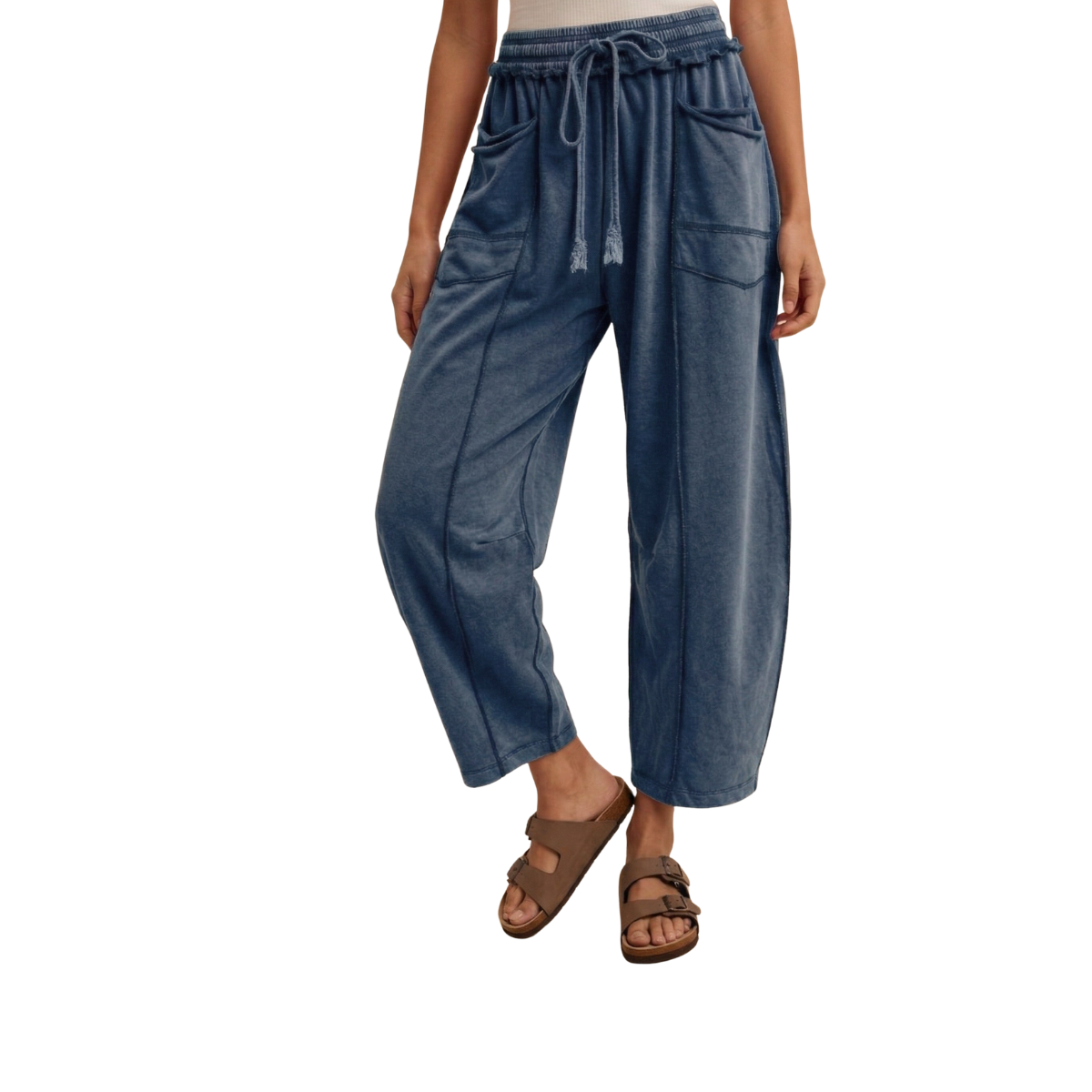 A person is wearing FASHION GO’s Mineral Wash Barrel Fit Utility Knit Pants, which feature a loose fit and side pockets, paired with brown sandals and standing against a white background.
