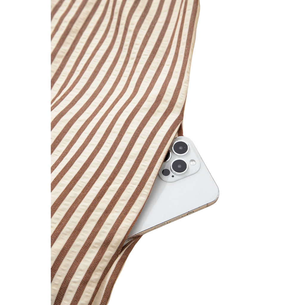A white smartphone is partially tucked into the pocket of the FASHION GO Leopard Trim Loose Bracelet Sleeve Shirt Dress, with only the camera side visible.