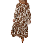 A woman is shown from the back against a white background, wearing the FASHION GO Floral Smocked Bodice Frill Tiered Dress—a long-sleeve, ankle-length brown and white floral print dress with a tiered skirt, perfect for summer garden parties—and holding a beige purse.