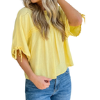 A woman wearing the FASHION GO Tie Half Sleeve Pleated Detail Babydoll Blouse— a loose-fitting yellow top with tie sleeves, crafted from lightweight, breathable fabric—paired with blue jeans, shown from shoulders to hips against a white background.