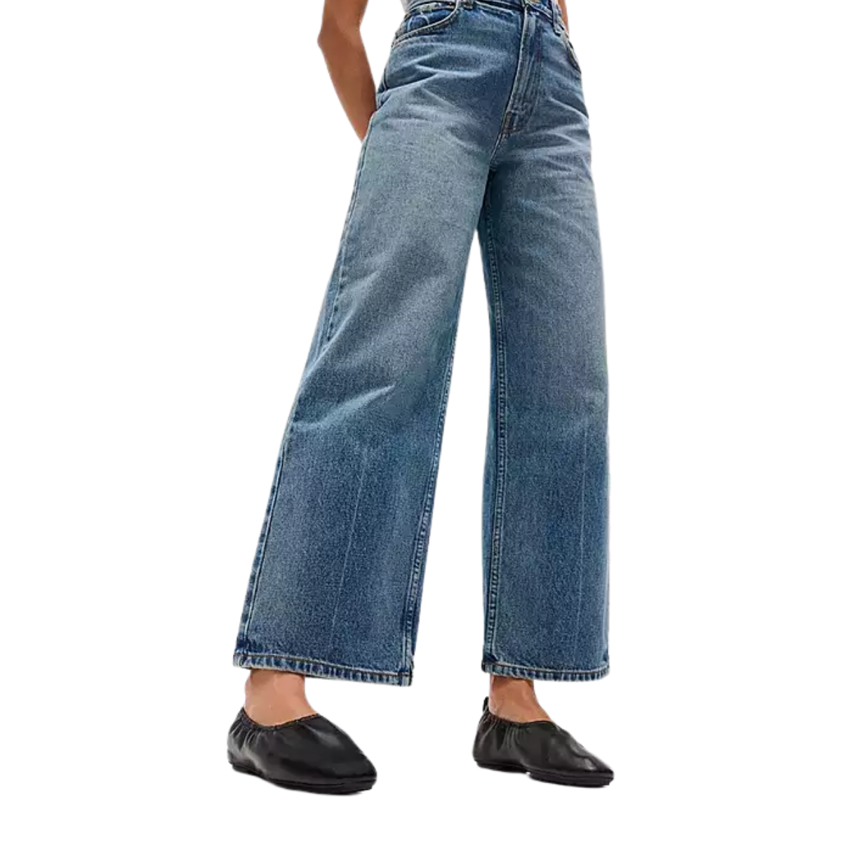 A person wears fit flop DELICATO Poise Leather Ballerinas with wide-leg blue jeans, standing against a white background. Only the lower half of their body is shown.