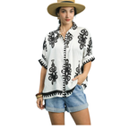 A woman wears the Umgee Abstract Print Top featuring a black and white oversized silhouette, paired with denim shorts and a straw hat, standing against a white background.