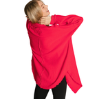 A person in a loose, bright red Zenana Gauze Button Down Top and black pants stands with arms raised, facing away from the camera.