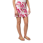 A person is shown from shoulders to feet wearing Pine Apparel’s Skort with Pockets in a pink and white floral print, styled with a white sleeveless top and tan sandals, against a plain background.
