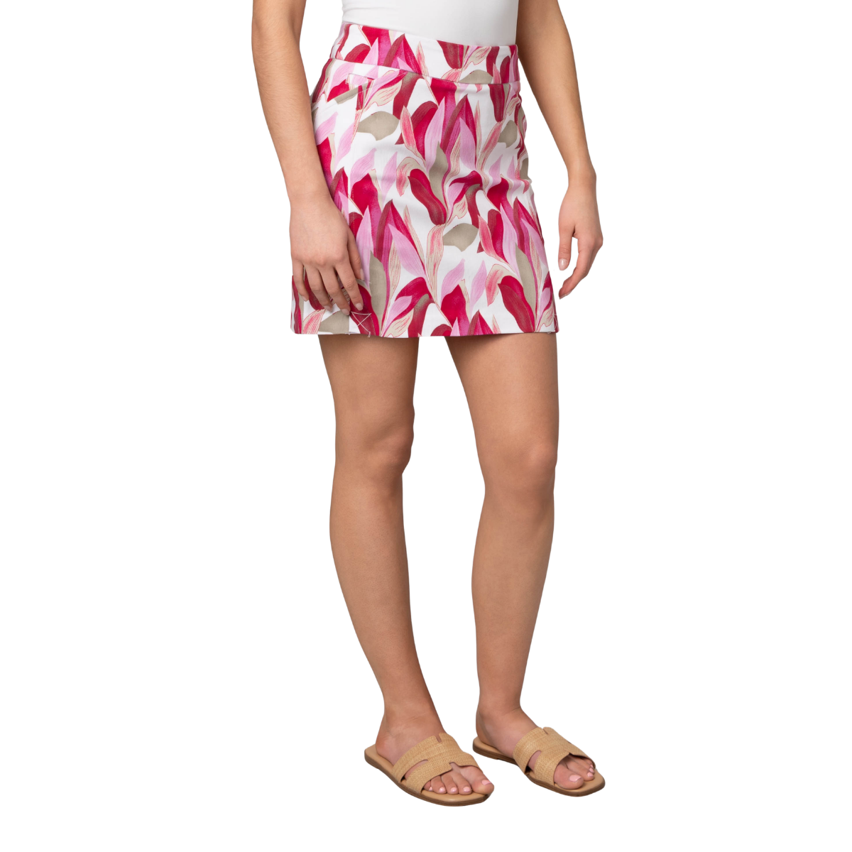 A person is shown from shoulders to feet wearing Pine Apparel’s Skort with Pockets in a pink and white floral print, styled with a white sleeveless top and tan sandals, against a plain background.
