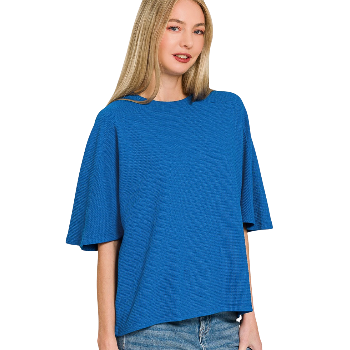 A woman with long blonde hair wears Zenana Double Knit Short Sleeve Tops with blue jeans, standing against a white background.