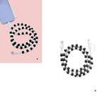 The Zenana Beaded DUAL USB FAST CHARGING CABLE in assorted colors is plugged into a smartphone on a pink and white background, providing universal compatibility for convenient charging.