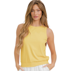 A woman with long, light brown hair wears the FASHION GO Women's Ribbed Viscose Crew Neck Tank in yellow and white pants, standing with one hand in her pocket.
