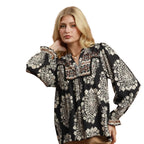Model wearing the Umgee Boho Paisley Blouse—black with brown collar and cuffs—posing against a white background.