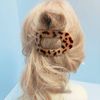 Blonde hair styled in a loose updo, secured with the ACCITY Oval Flat Hair Clip for Women, against a light blue background.