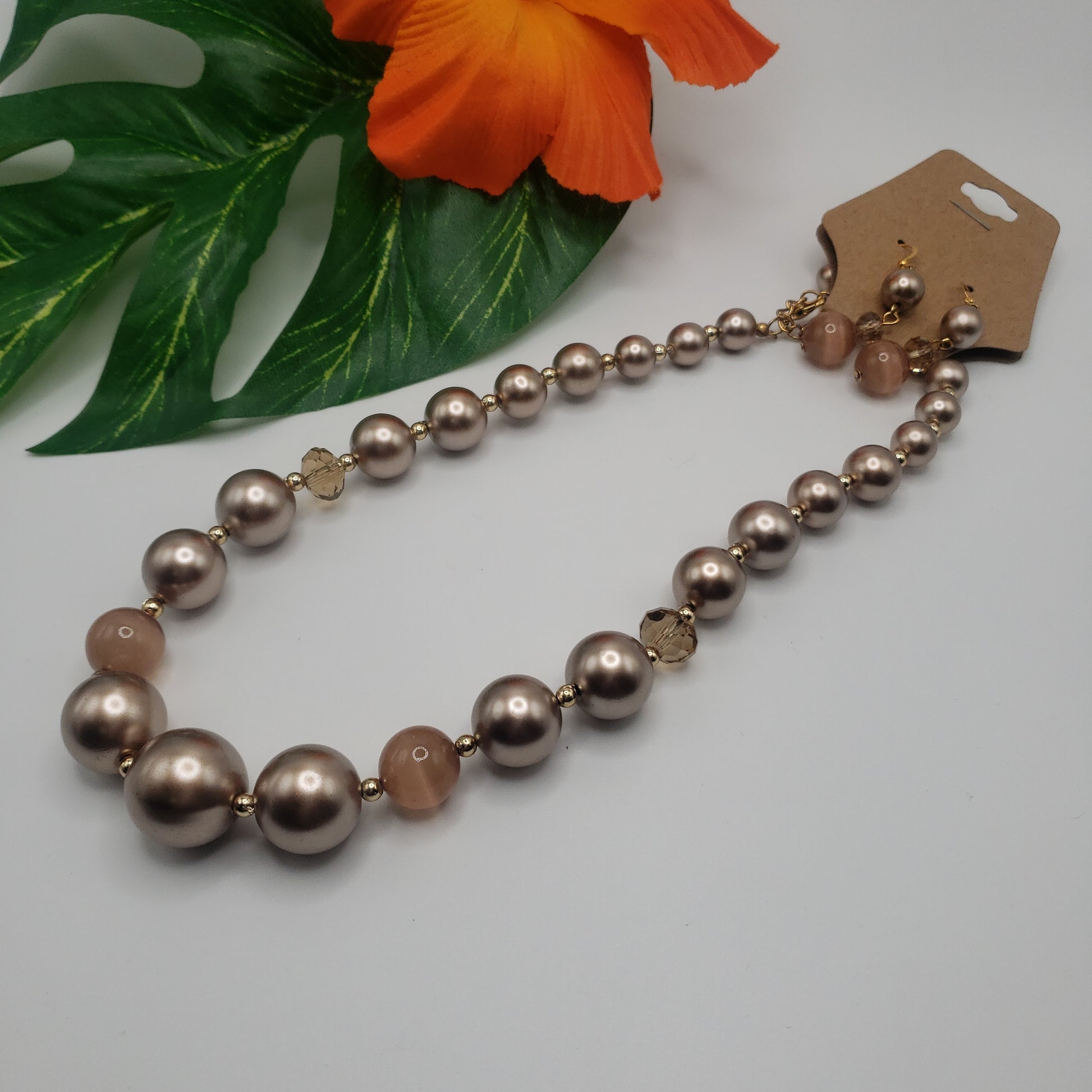 A "CHAMPAGNE BEADS 17"" NECKLACE SET" by SPECIAL EFFECTS with pearls and a flower on it.