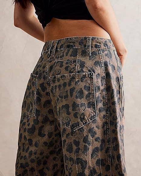 A person is seen from the back wearing Dipped Shop’s Leopard Print Loose Midi Waist Wide Leg Jeans in brown and black micro stretch denim.