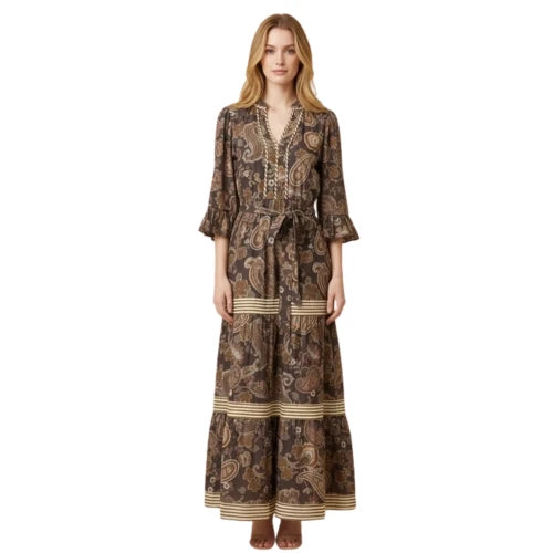 A woman stands against a white background wearing the FASHION GO Brown Boho Print Paisley Dress, a maxi dress with a tie waist, ruffled sleeves, horizontal striped accents near the hem, and a split V-neckline that creates a relaxed, bohemian vibe.