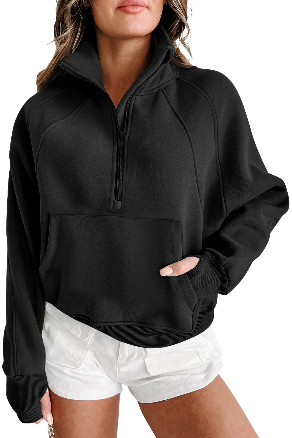 A person wearing a gray zip-up stand collar ribbed sweatshirt with thumbhole sleeves from Shewin and white shorts, with one hand in the front pocket.