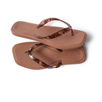 A pair of REEF Solaye Flip Flop in Tortoise, featuring square soles and marbled tortoise-print straps, are placed overlapping on a white background. These water-friendly sandals offer a stylish yet functional option for everyday wear.