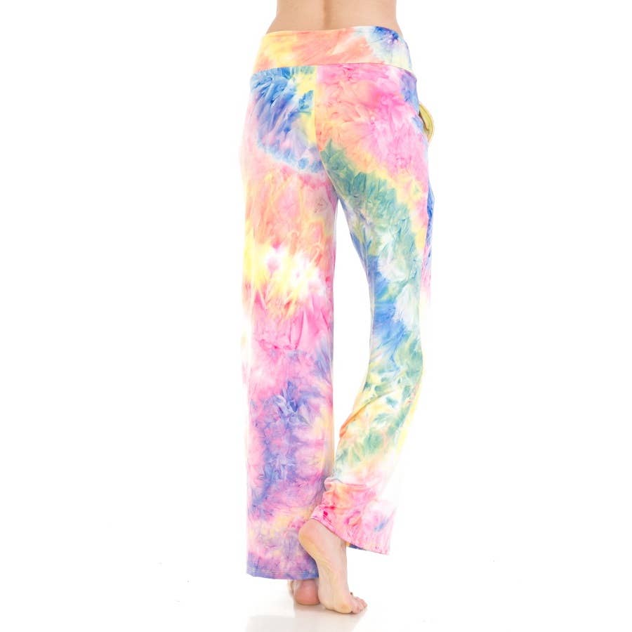 A person is standing barefoot against a white background, wearing Leggings Depot Buttery Soft Print Pajama Pants featuring a loose fit, high waist, elastic waistband, and pink, yellow, blue, and green tie dye print.