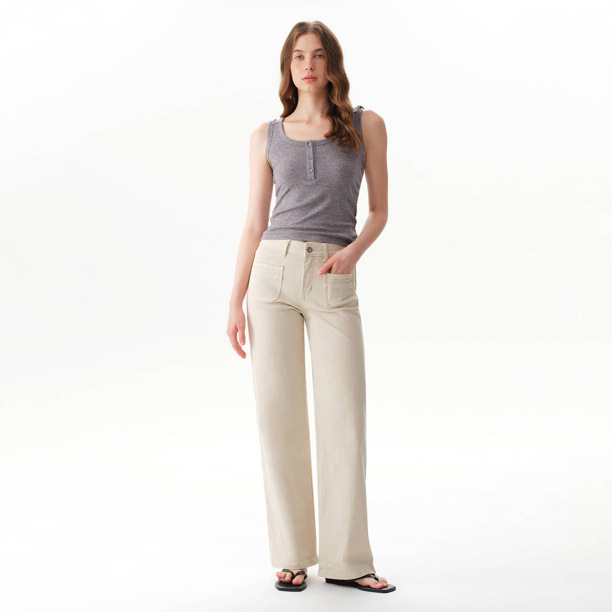 A person wearing a grey tank top and Faire Off White Mid Rise Straight Pants featuring front patch pockets.