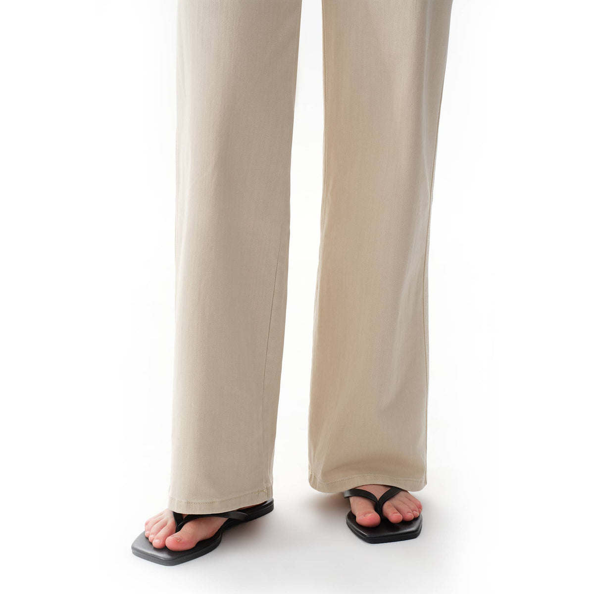 Off White Mid Rise Straight Pants in a neutral tone with straight-leg styling, worn with black thong sandals.