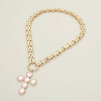 Sensibling Corp. Pearl Cross Charm Pendant Chunky Chain Statement Necklace displayed on a plain light background, featuring a textured cross adorned with six round pink gemstones.