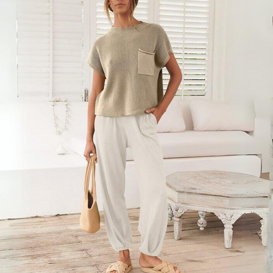 Woman in a casual beige 2 Piece Knit Sweater and Pant Set from FASHION GO holding a tote bag standing in a bright room.